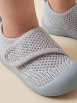Puschies Barfußschuh Grau — weiche flexible Sohle am Babyfuß Nahaufnahme