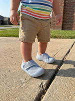 Baby mit Babyloom Puschies Barfußschuhe Blau auf der Terrasse