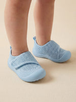 Puschies Barfußschuh Blau am Babyfuß — weiche Sohle für natürliche Fußentwicklung