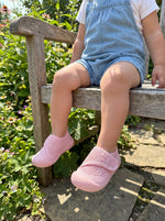 Baby mit Babyloom Puschies Barfußschuhe Rosa auf der Wiese