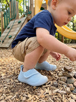 Kleinkind spielt draußen mit Babyloom Puschies Blau Barfußschuhen