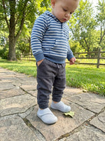 Kleinkind spielt draußen mit Babyloom Puschies Grau Barfußschuhen