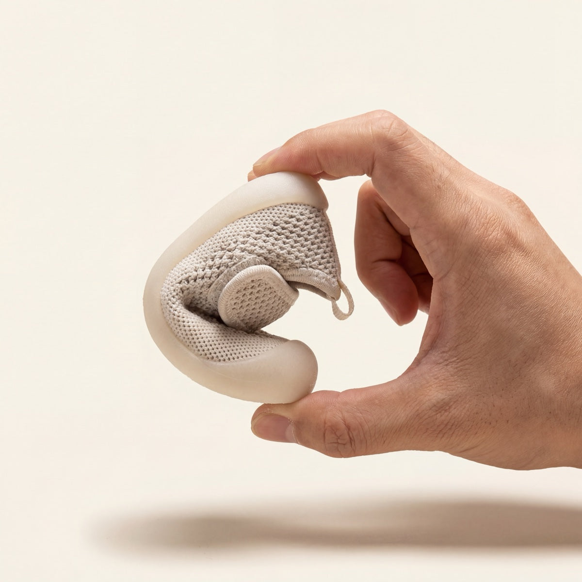 Hand biegt Babyloom Puschies — extreme Flexibilität, weich wie Socken